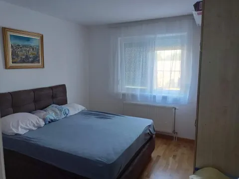 Spavaća soba sa bračnim krevetom, prozorom i umetničkom slikom na zidu. - image 4