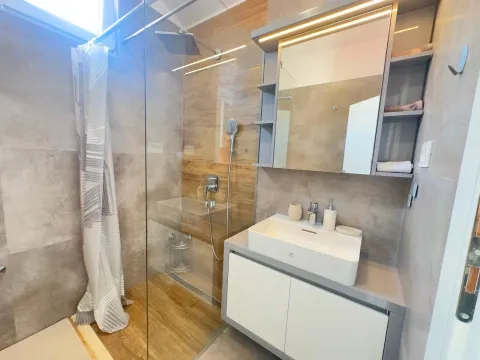 Modern bathroom with a walk-in shower and vanity. - image 13