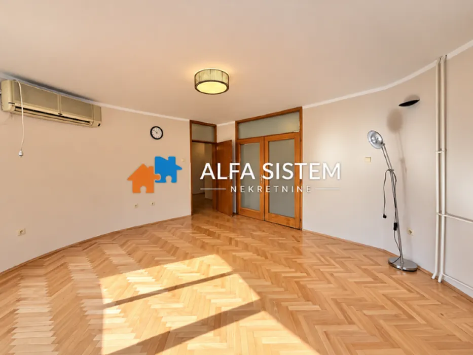 Empty living room with parquet flooring and an air conditioner.