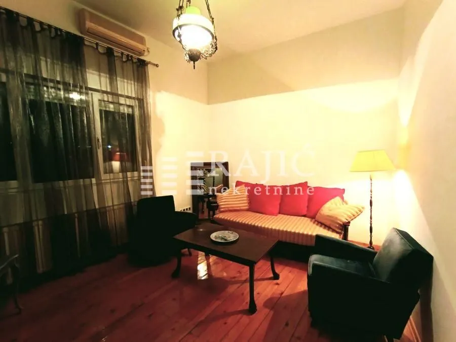 Living room with sofa set and wooden floor.