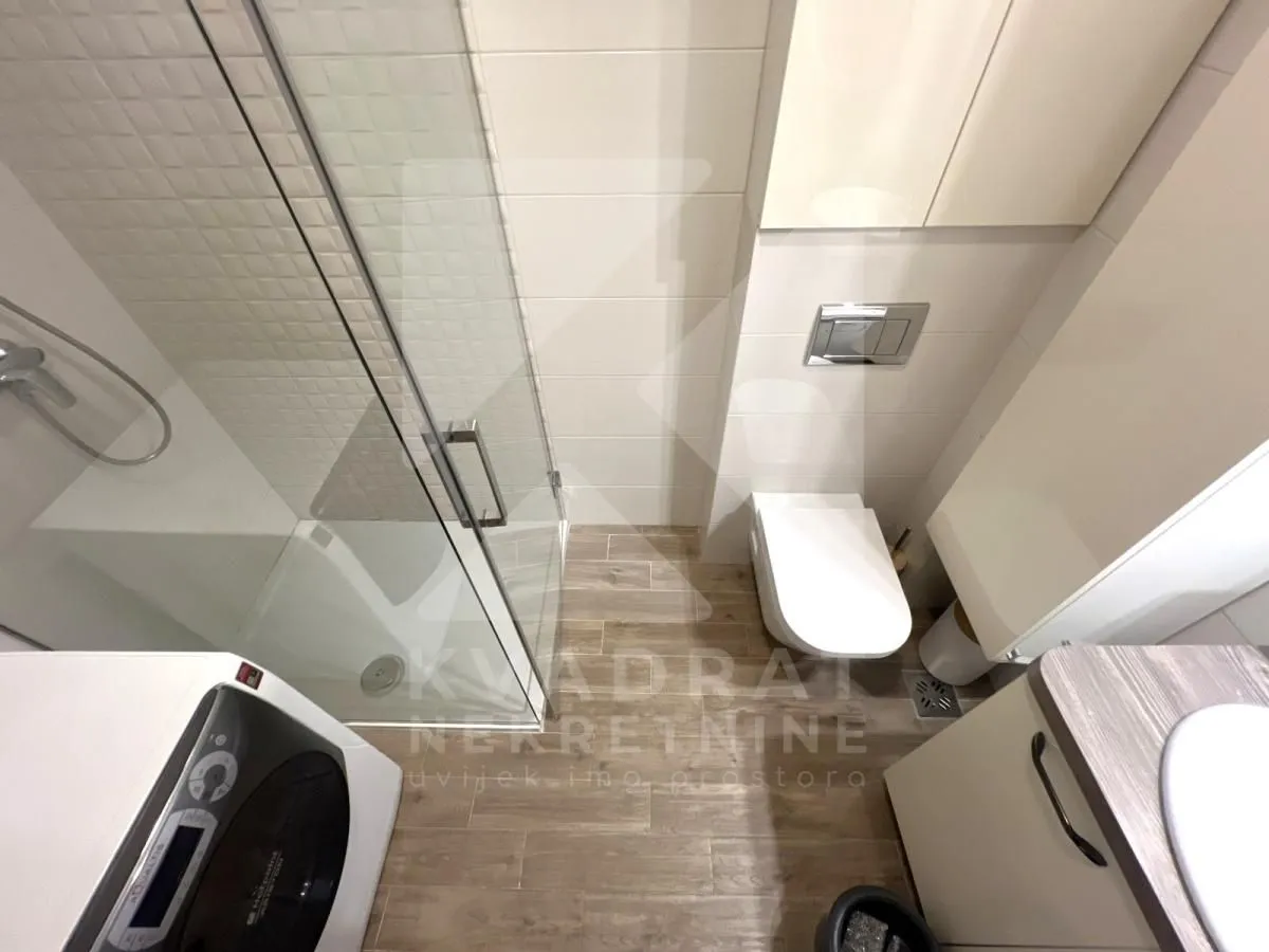 Manje kupatilo sa tuš kabinom, WC šoljom i umivaonikom.