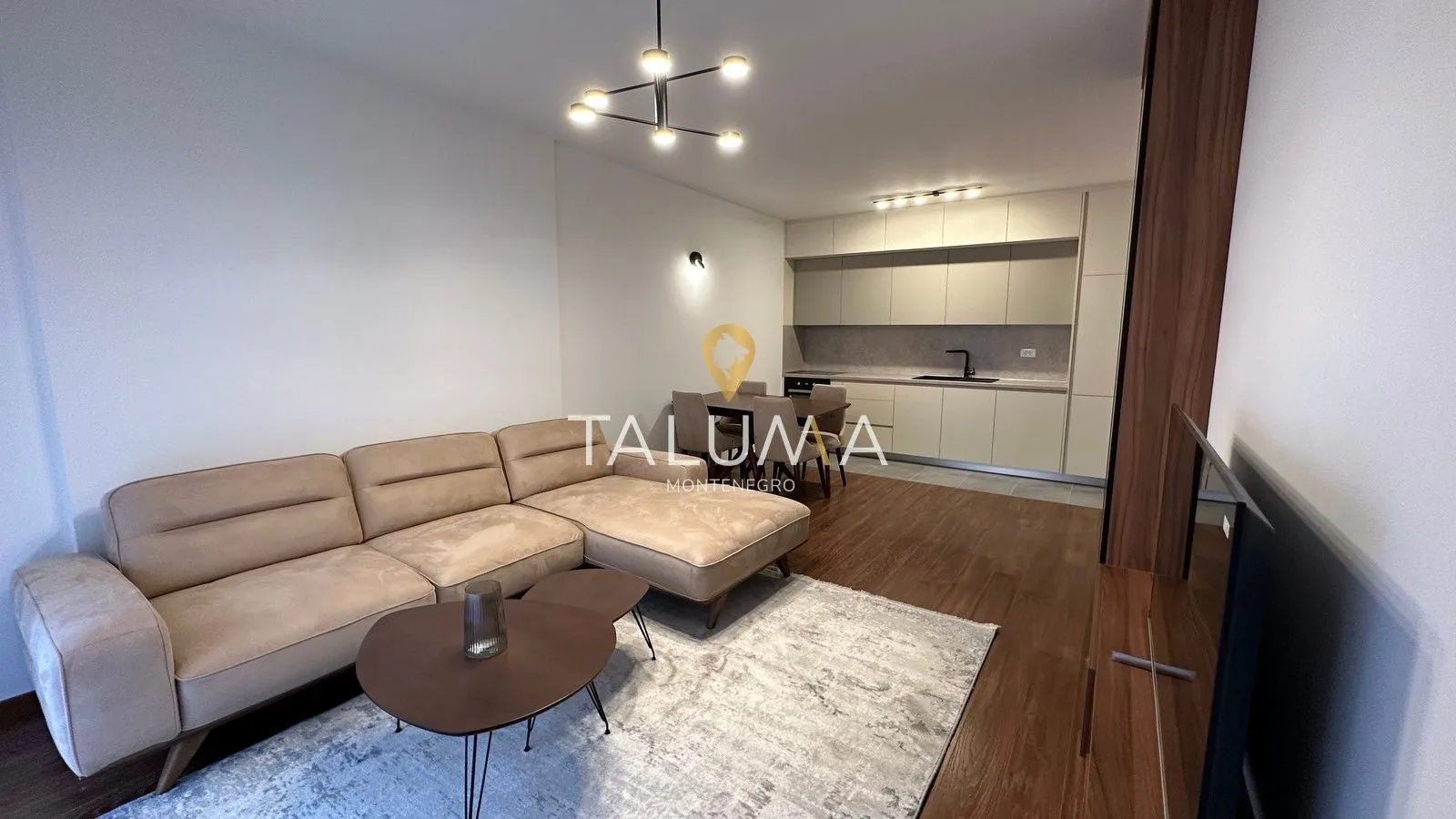 Living room with sofa and dining area connected to the kitchen.