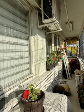 Uski balkon sa saksijama cveća i spoljnom jedinicom klima uređaja. - image 14
