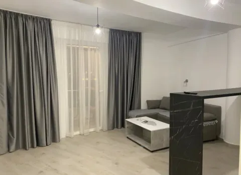 Dnevna soba sa ugaonom garniturom, stočićem i velikim prozorom sa zavesama. - image 3