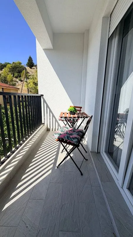 Furnished balcony with a table and chairs and a view of nature.