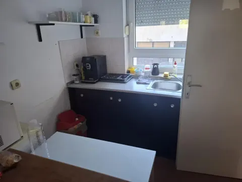 Manja kuhinja sa sudoperom, radnom površinom i aparatom za kafu pored prozora. - image 7