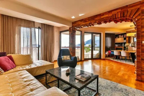 Spacious living room featuring a leather sofa and an ornamental wooden arch. - image 13