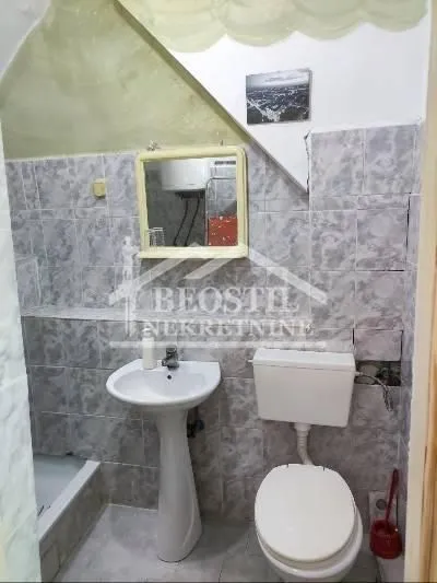 Smaller tiled bathroom with a sink and a toilet.
