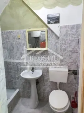 Smaller tiled bathroom with a sink and a toilet. - image 9