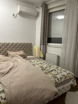 Nameštena spavaća soba sa bračnim krevetom, prozorom i klima uređajem. - image 2