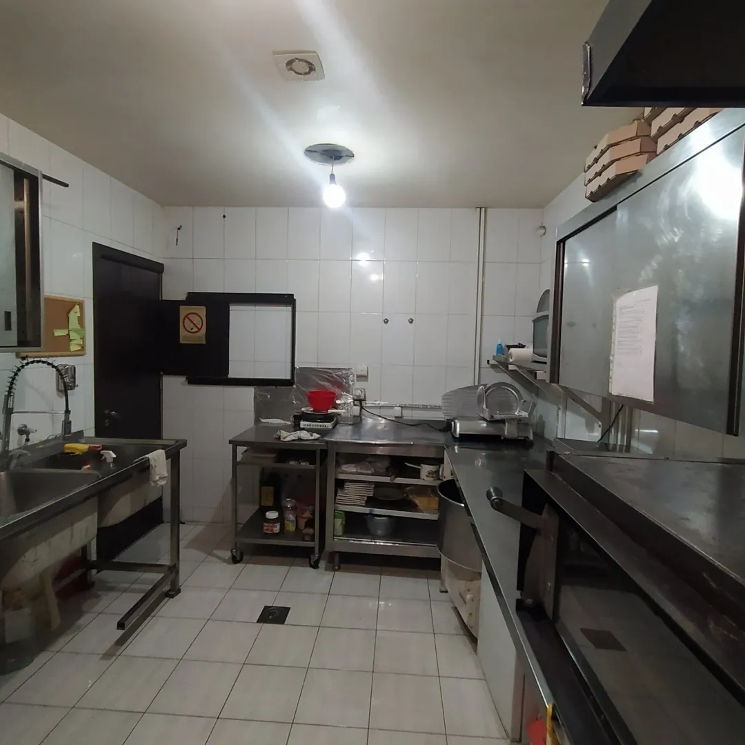 Komercijalna kuhinja sa inox radnim površinama i sudoperom.