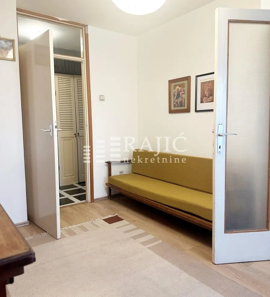 Living room with a sofa and wooden doors.
