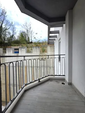 Nenamješten balkon sa metalnom ogradom i pogledom na spoljašnjost. - image 3