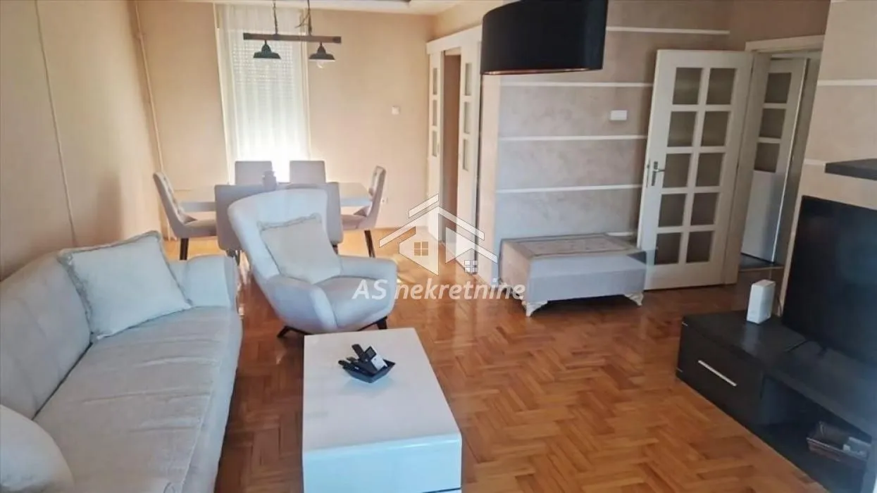 Furnished living room with a sofa set and a dining area in the background.