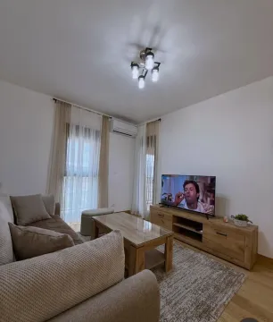 Furnished living room with a sofa, coffee table, and TV. - image 3