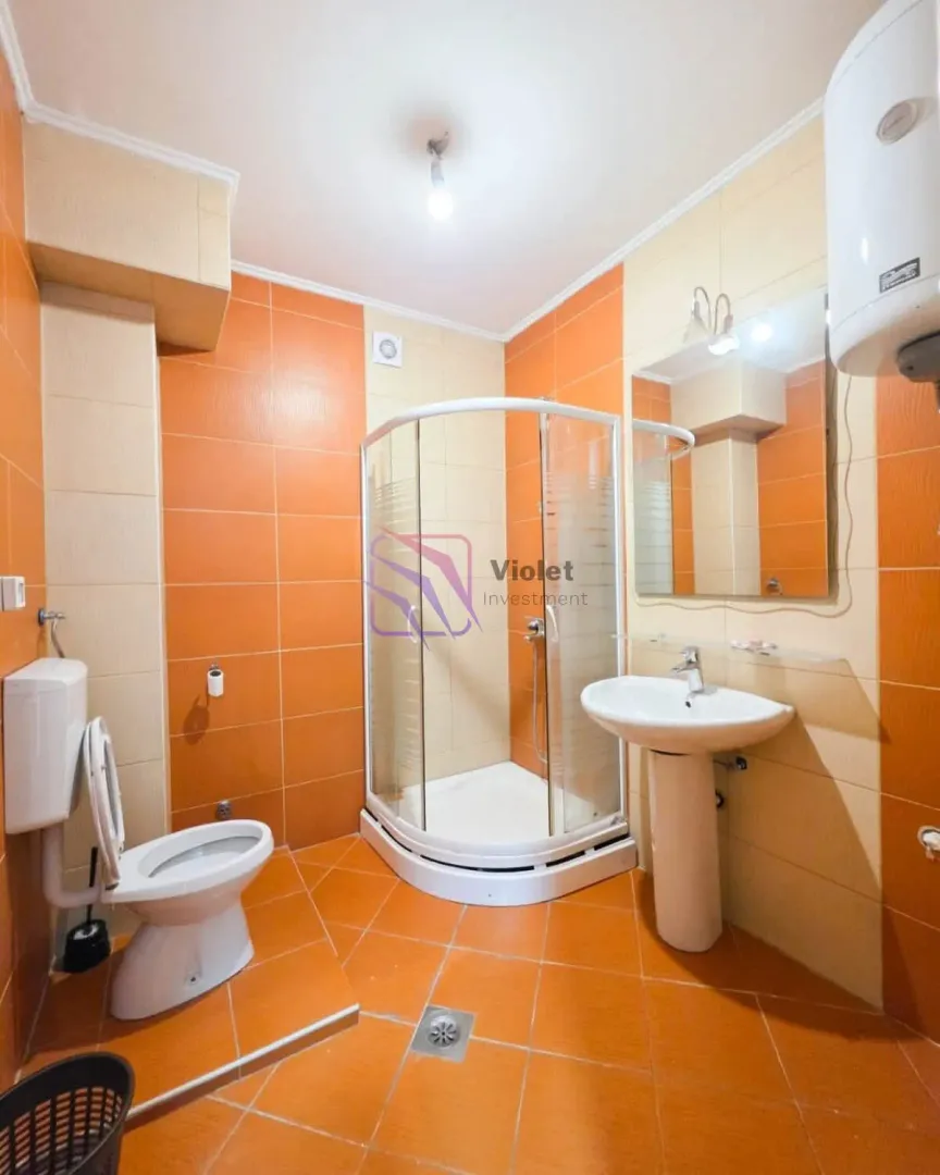 Bathroom with a shower cabin, washbasin, and toilet.
