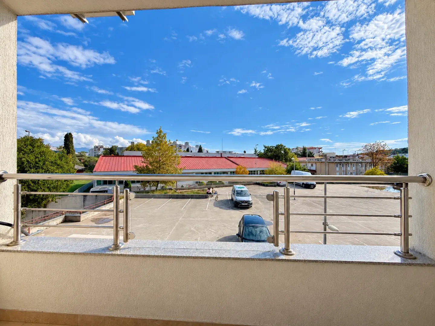 View from the balcony overlooking the parking lot and surrounding buildings.
