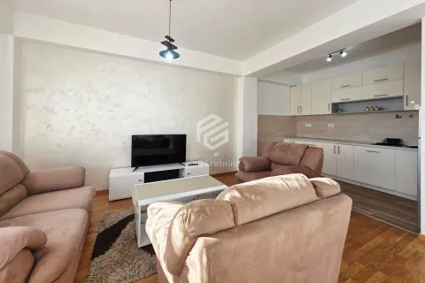 Spacious living room with a sofa set and television, connected to the kitchen in the background. - image 2