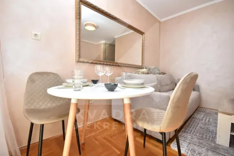 Living room with a dining table, sofa, and a large wall mirror. - image 4