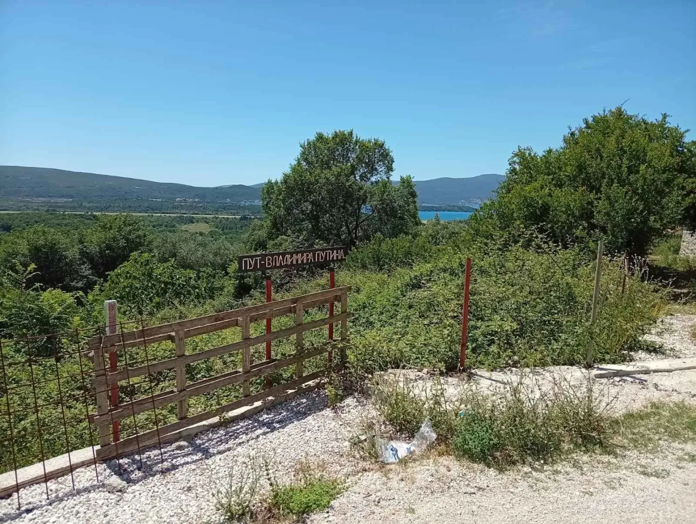 Pogled na okolni krajolik i zelenilo sa uličnim znakom.