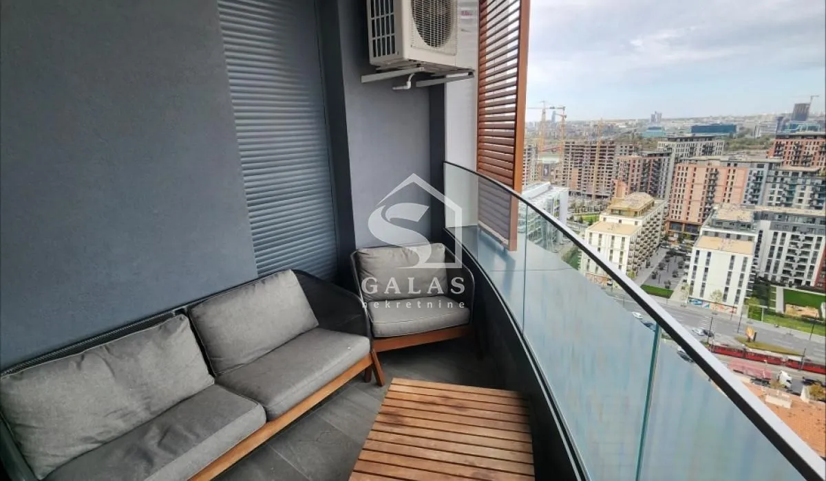Furnished balcony with seating set and city view.