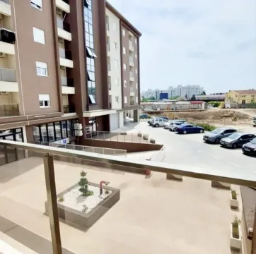 Pogled sa terase na zgradu i parking sa vozilima. - image 4