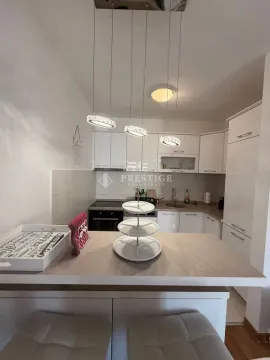 Modern kitchen with a breakfast bar and white cabinetry. - image 5