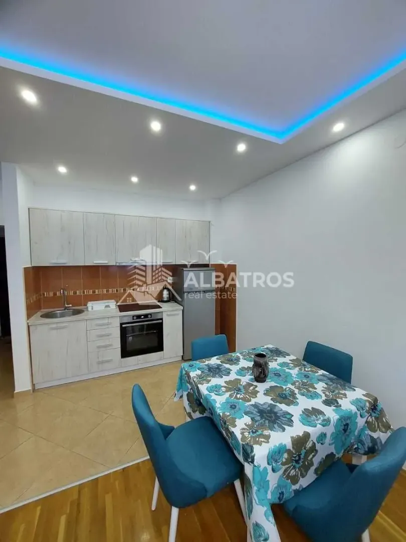 Small kitchen with a dining table and blue chairs.