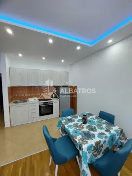 Small kitchen with a dining table and blue chairs. - image 4