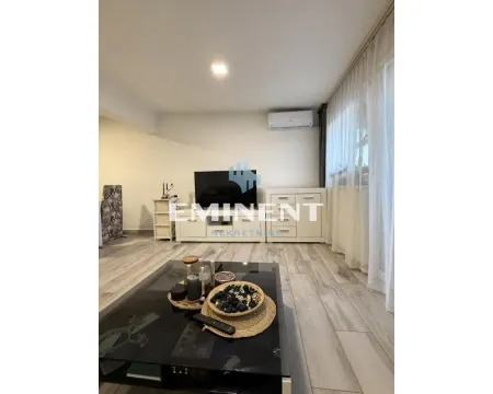 Living room with a television, coffee table, and a window with white curtains. - image 2
