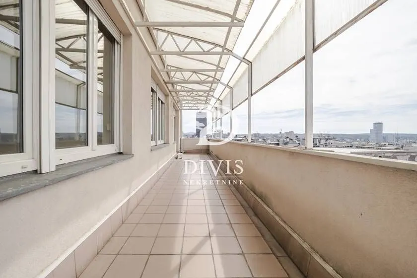 Dugački natkriveni balkon sa pogledom na grad.
