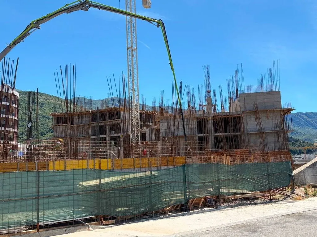 Stambeni objekat u izgradnji sa betonskom konstrukcijom i kranom.