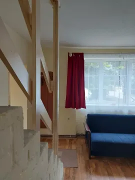 Dnevna soba sa kaučem, prozorom i drvenim stepeništem. - image 15