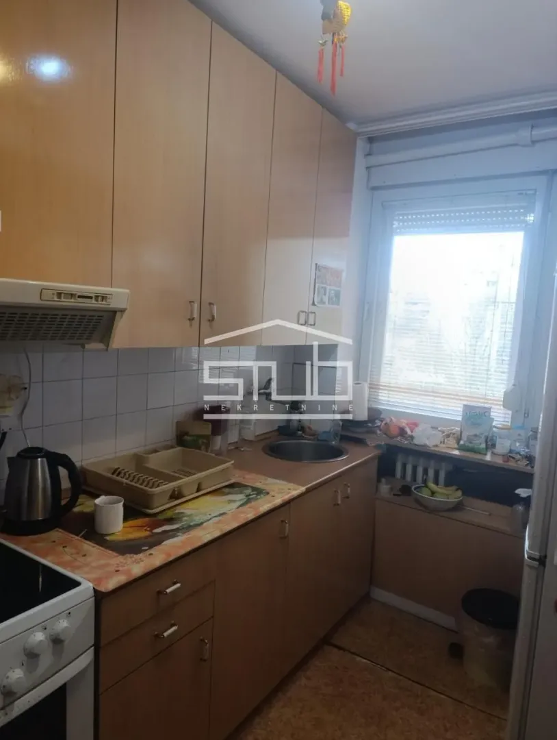 Small kitchen with wooden cabinetry and a window.