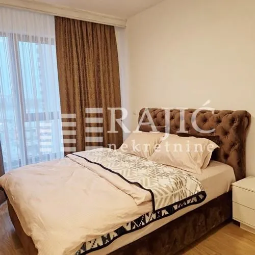 Bedroom with a double bed and a window with curtains.