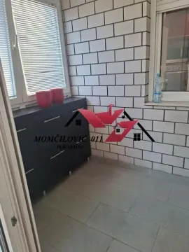 Zastakljena terasa sa pločicama na podu i komodom. - image 8