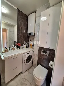 Moderno kupatilo sa umivaonikom, WC šoljom, veš mašinom i velikim ogledalom. - image 11