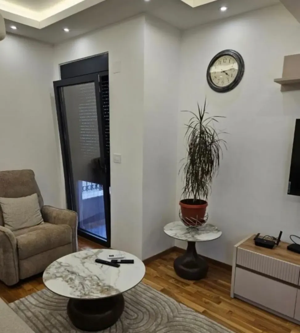 Furnished living room with an armchair, coffee table, and TV unit.