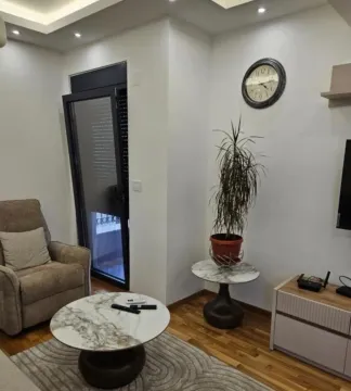 Furnished living room with an armchair, coffee table, and TV unit. - image 2