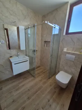 Savremeno opremljeno kupatilo sa tuš kabinom i umivaonikom. - image 13