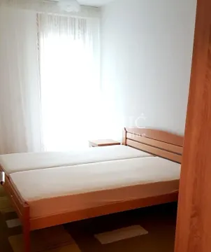 Bedroom with a double bed and a window with white curtains. - image 6