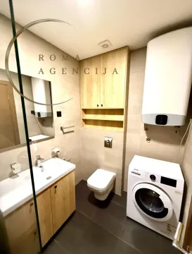 Modern equipped bathroom with a washbasin, toilet, and washing machine. - image 9