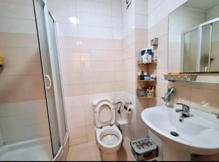 Kupatilo sa tuš kabinom i lavaboom.