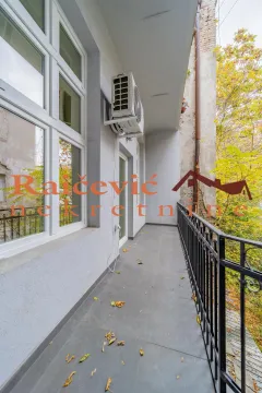 Long balcony with tile flooring and a metal railing along the building facade. - image 9