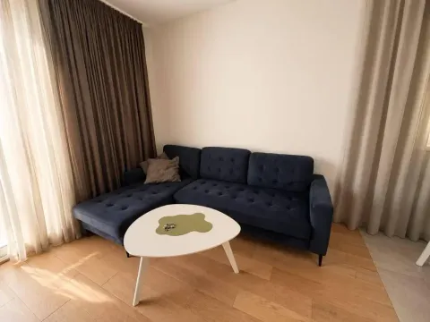 Living room with a dark blue sectional sofa and a white coffee table. - image 7
