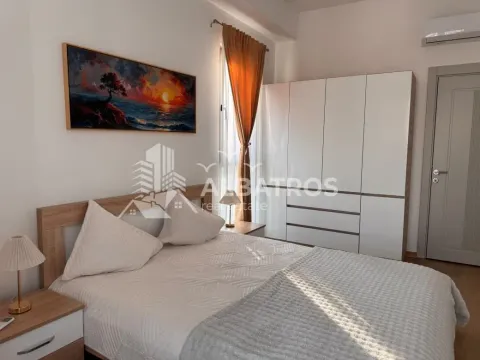 Furnished bedroom with a double bed, white wardrobe, and a painting on the wall. - image 6