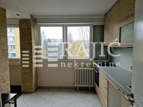 Small kitchen with wooden cabinetry and a window.