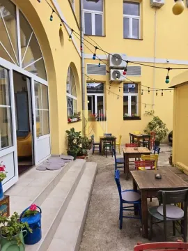 Dvorište zgrade sa stolovima i stolicama za kafić. - image 11