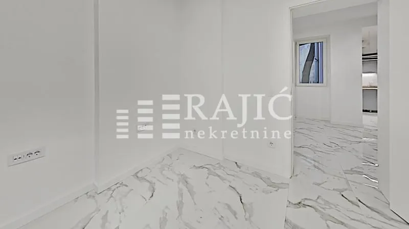 Empty bright room with marble floor tiles and a view of the hallway.