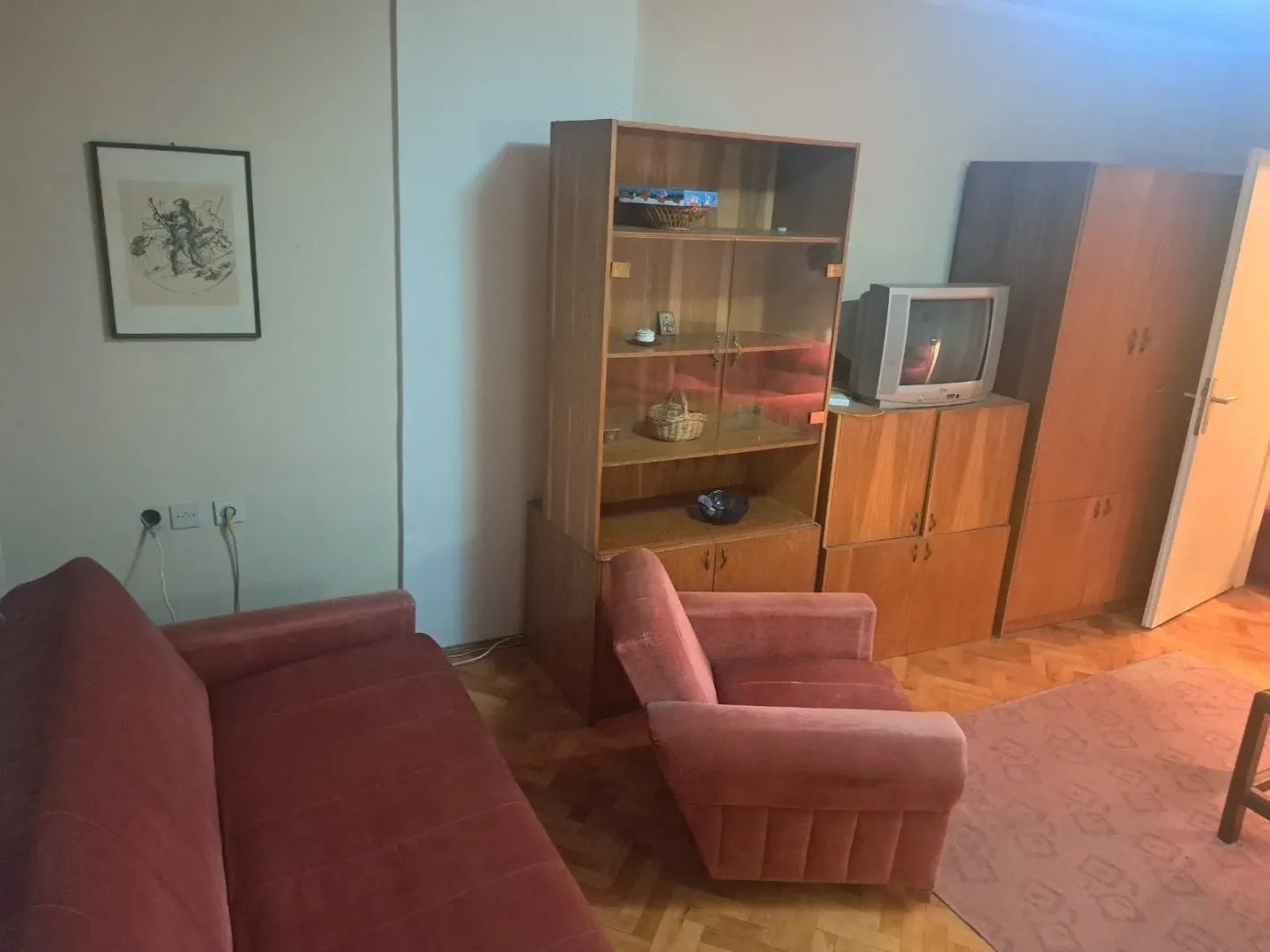 Living room with a sofa, armchair and wooden furniture.